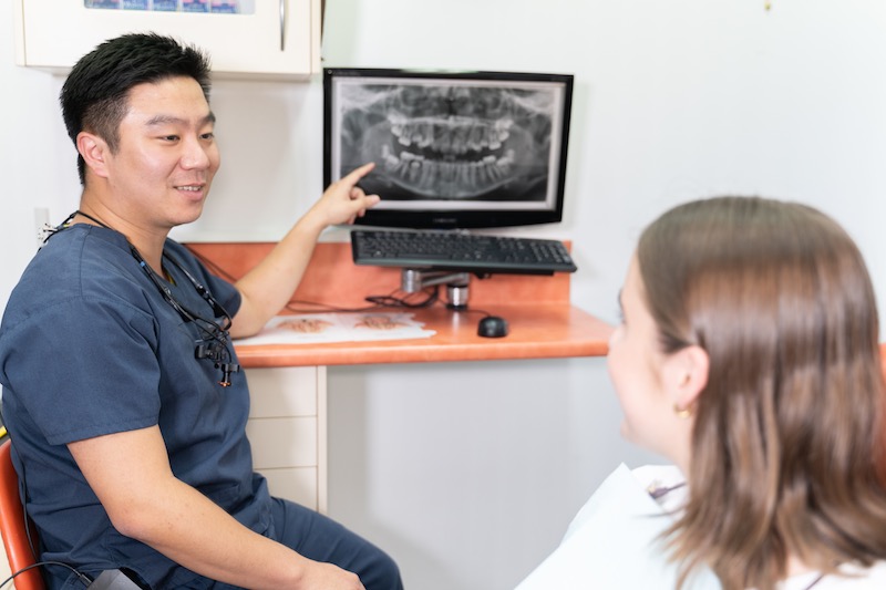 Jacky Yu teaching patient how to brush teeth to prevent decay